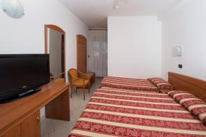 a hotel room with two beds and a flat screen tv at Hotel Villa Linda - Family Hotel - Nuova Costruzione Antisismica in Riccione