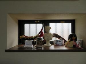 - une étagère avec une poupée et un miroir dans l'établissement Azalea, à Osaka