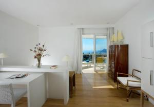 a living room with a white table and chairs and a window at Relais Blu in Massa Lubrense