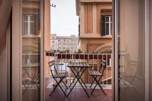 uma varanda com uma mesa e cadeiras. em HospitalityRome Domus Aureliana em Roma