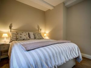 a bedroom with a bed and a night stand with two lamps at Mill Race in Burford