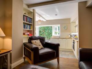 a living room with a chair and a kitchen at Mill Race in Burford