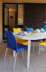 ein weißer Tisch und Stühle mit einem Teller Essen drauf in der Unterkunft VVF Soulac-sur-Mer Bordeaux Médoc in Soulac-sur-Mer