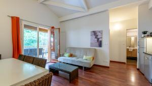 ein Wohnzimmer mit Sofa und Tisch in der Unterkunft Vacancéole - Les Rives du Lac in Lacanau