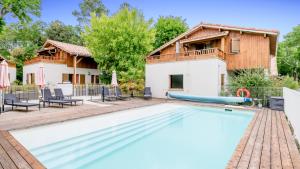 eine Villa mit Swimmingpool und ein Haus in der Unterkunft Vacancéole - Les Rives du Lac in Lacanau