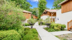 einen Garten mit Bäumen und Sträuchern in der Unterkunft Vacancéole - Les Rives du Lac in Lacanau