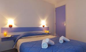ein Schlafzimmer mit einem Bett mit zwei weißen Handtüchern darauf in der Unterkunft VVF Soulac-sur-Mer Bordeaux Médoc in Soulac-sur-Mer