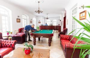 un hombre jugando al billar en una sala de estar en Walzer Hotel en Budapest