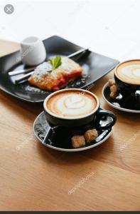 drie kopjes koffie op een tafel met eten bij Ararat House in Tsandrypsj