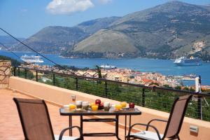 stół i krzesła na balkonie z widokiem w obiekcie The "L" Suites & Apartments w mieście Argostoli