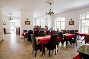 Walzer Hotel في بودابست: غرفة طعام مع طاولات حمراء وكراسي سوداء