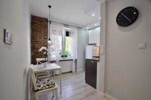 a kitchen with a table and a clock on the wall at Apartament Grey in Busko-Zdrój