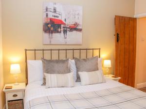1 dormitorio con 1 cama blanca grande y 2 lámparas en Tub Boat Cottage en Telford