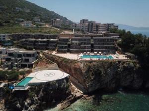 a hotel on a cliff next to the water at Aneta's Beach House in Vlorë