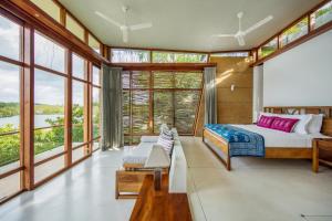 a bedroom with a king sized bed and large windows at Tri by Amaya in Ahangama +37 photos