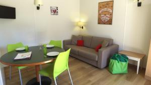 a living room with a table and a couch at VVF Les Ecrins Champsaur in Saint-Bonnet-en-Champsaur