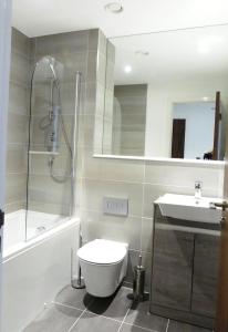 a bathroom with a shower and a toilet and a sink at Churchill Place - Downtown Luxury Apartments in Basingstoke