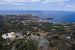 een luchtzicht op een stad op een heuvel bij de oceaan bij Olenia Residence in Agia Pelagia