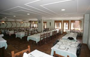 a dining room with white tables and chairs at Hosteria Peña Sagra in Ojedo