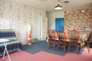 a dining room with a table and chairs and a couch at Guest House Japan Heart in Hokuto