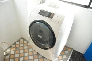 a washing machine in a corner of a bathroom at Guest House Japan Heart in Hokuto