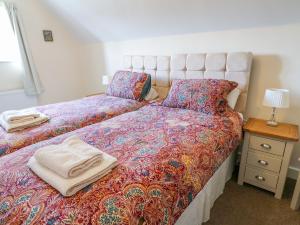 Tempat tidur dalam kamar di Ardsley Cottage - Longford Hall Farm Holiday Cottages