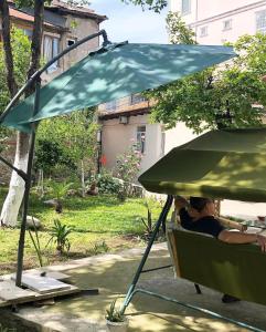 una persona sentada en una silla bajo un paraguas en Batumi Summer Hotel en Batumi