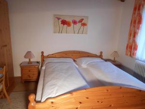 un letto in legno in una camera da letto con 2 comodini di Haus Amalia a Strobl