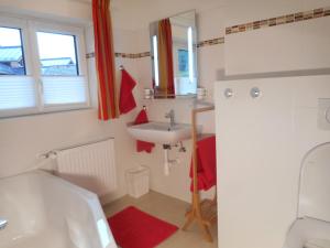 een badkamer met een wastafel, een toilet en een bad bij Haus Amalia in Strobl