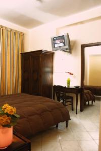 Schlafzimmer mit einem Bett, einem Tisch und einem TV in der Unterkunft Hotel Piro in Torrenova