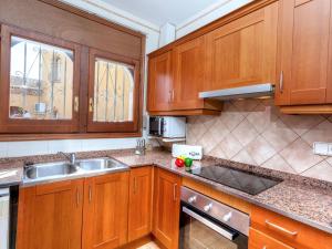 una cocina con armarios de madera y fregadero en Villa Estrella by Interhome en Hospitalet de l'Infant