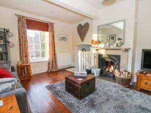 a living room with a fireplace and a mirror at Pelham House Cottage in Market Rasen