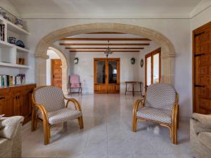 a living room with two chairs and an archway at Holiday Home Adsubia by Interhome in Jávea