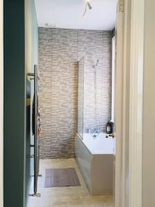 a bathroom with a bath tub and a shower at Bright Apartment in the Heart of St Leonards in Hastings