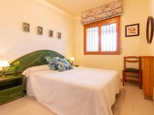 1 dormitorio con 1 cama con manta blanca y ventana en Holiday Home Fumadell by Interhome, en Riumar