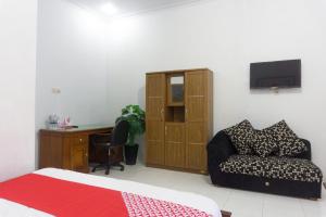 OYO 801 Hansa Homestay في باكيتان: غرفة نوم بسرير ومكتب واريكة