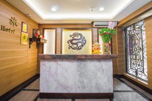a hotel lobby with a counter with a dragon on the wall at Longshan Inn in Taipei