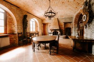 een eetkamer met een tafel en een bakstenen muur bij Villa Barbero Alba in Mango