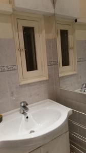 a bathroom with a white sink and a mirror at Appartement indépendant in Bastia