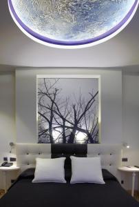 - une chambre avec un lit orné d'une peinture d'un arbre dans l'établissement Hotel Campoamor, à Oviedo