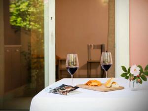 マリーナ・ディ・ビッボーナにあるApartment Relais-2 by Interhomeの赤ワイン2杯とパン付きテーブル