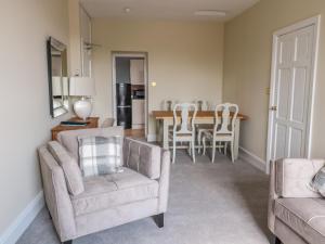 a living room with two chairs and a table at Coquet View Apartment in Morpeth