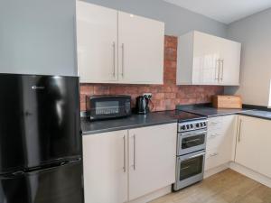 モーペスにあるCoquet View Apartmentの白いキャビネットと黒い冷蔵庫のあるキッチン +18枚の写真
