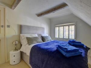a bedroom with a bed with blue sheets and a window at Holiday Home Ephraim-2 by Interhome in Royal Tunbridge Wells
