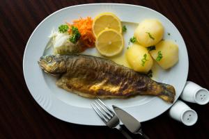 a plate of food with a fish and vegetables at Berggasthof Ziegenkopf in Blankenburg