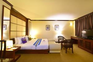 una camera d'albergo con letto, tavolo e sedie di Grand Business Inn a Bangkok
