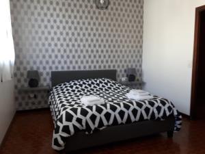 a bedroom with a bed with a black and white comforter at Les Sables Blancs in Saint-Julien-en-Born