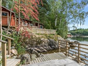 a house on the shore of a river with a wooden bridge at Holiday Home Koivula by Interhome in Vuoriniemi