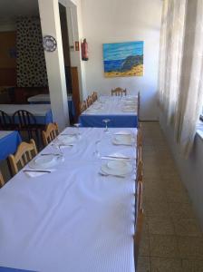 una fila de mesas con platos y vasos. en Monte Estrela en Sabugueiro