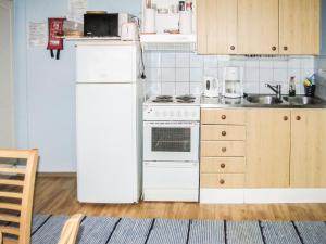 a kitchen with a white refrigerator and a stove at Holiday Home Koivula by Interhome in Vuoriniemi